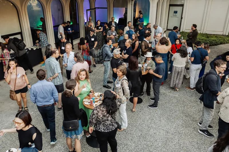 An overhead view shows a large reception crowd filling the venue courtyard.